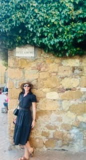Sandra Hodes standing beside a stone wall