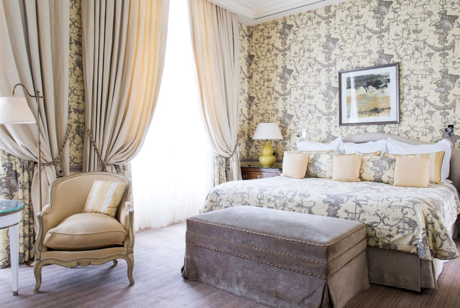 A bed with patterned walls, draperies and classic French decor
